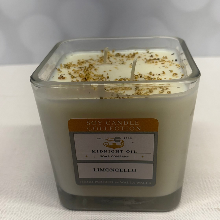 Square glass candle with a label on a white background