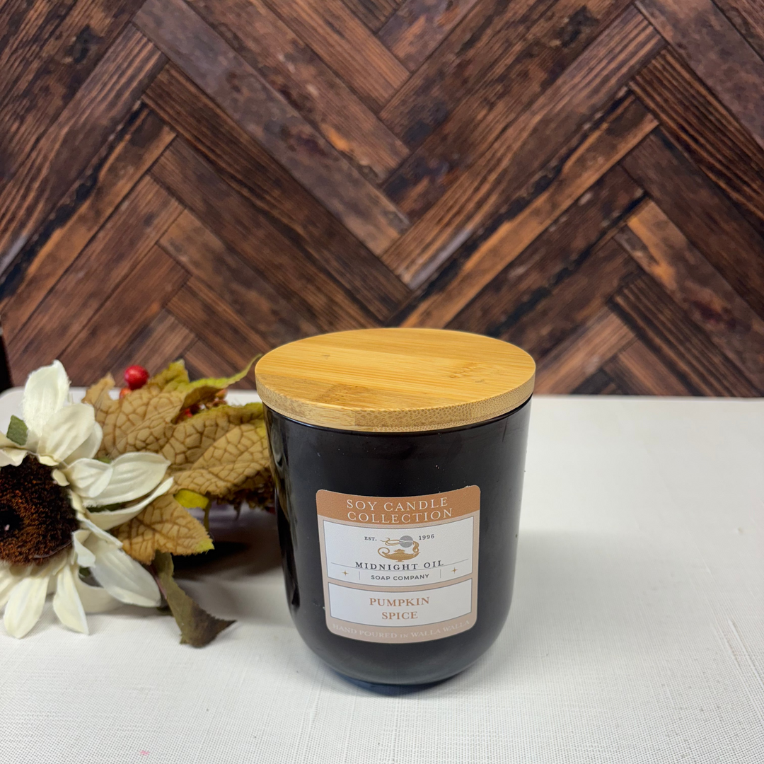 pumpkin spice soy candle with wooden lid on a dark brown glass vessel